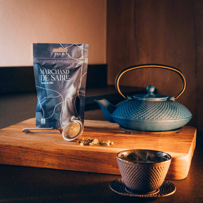 Sachet de la tisane au CBD marchand de sable posé sur une table prêt à servir